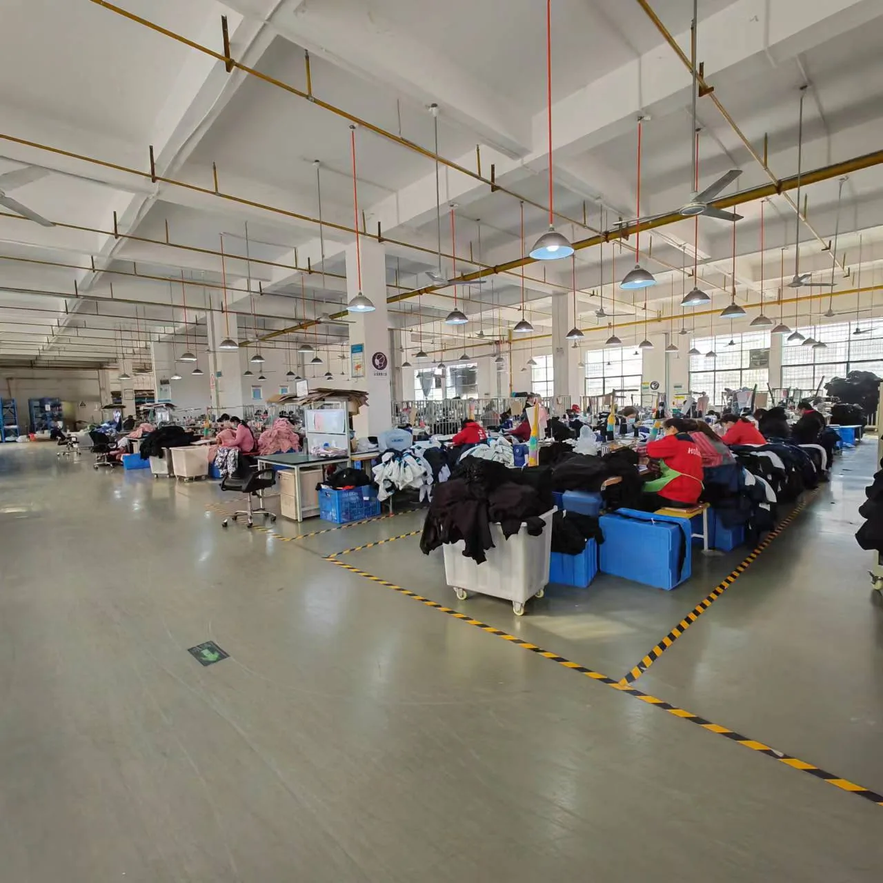 Piso de costura de sudaderas y sudaderas en la fábrica SLSPOLO en Dongguan
