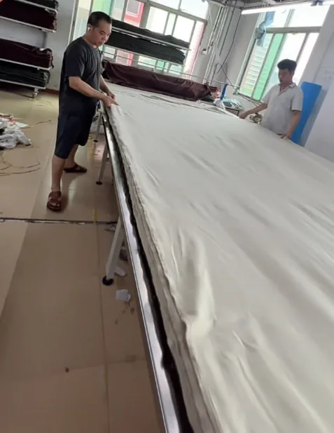 T シャツを大量にカットする前に、生地をカッティング テーブル上に重ねて広げます