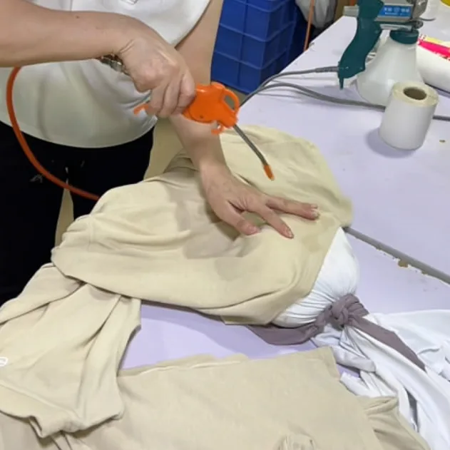 仕上げ中にTシャツパネルの汚れを検査する